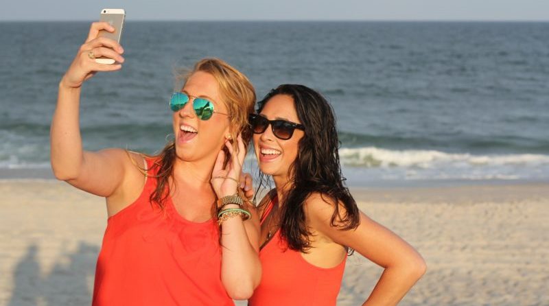 dwie dziewczyny robiace selfie na plazy